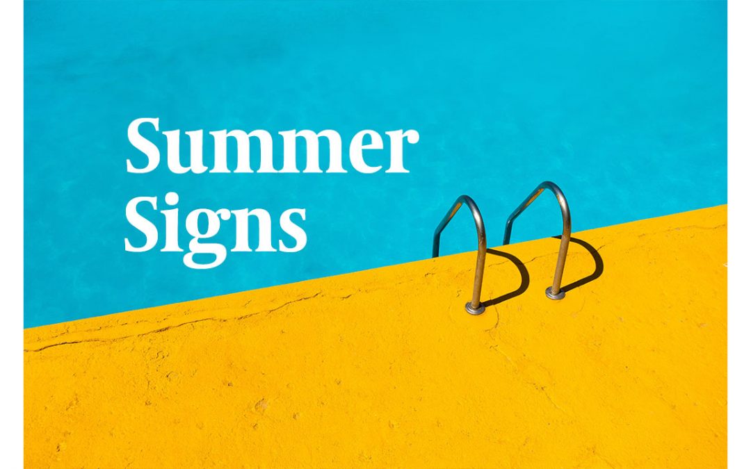 image shows the edge of a pool with blue water and a yellow deck. Text says summer signs. Photo by Etienne Girardet on Unsplash