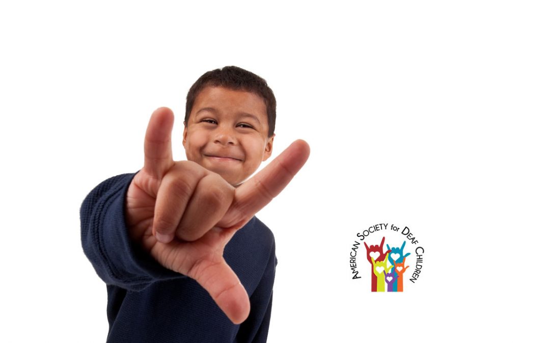 image shows a pre-teen Hispanic boy showing the ASL sign for "I love you"