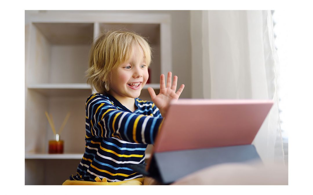 child is waving at a computer screen