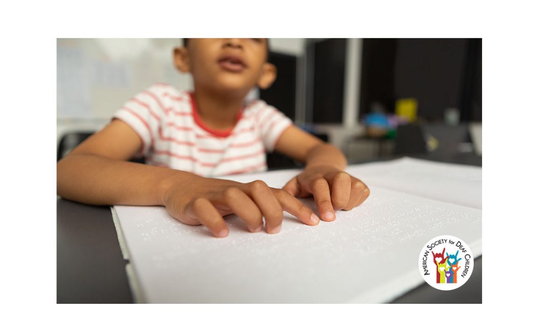 image shows a child running fingers over Braille textbook