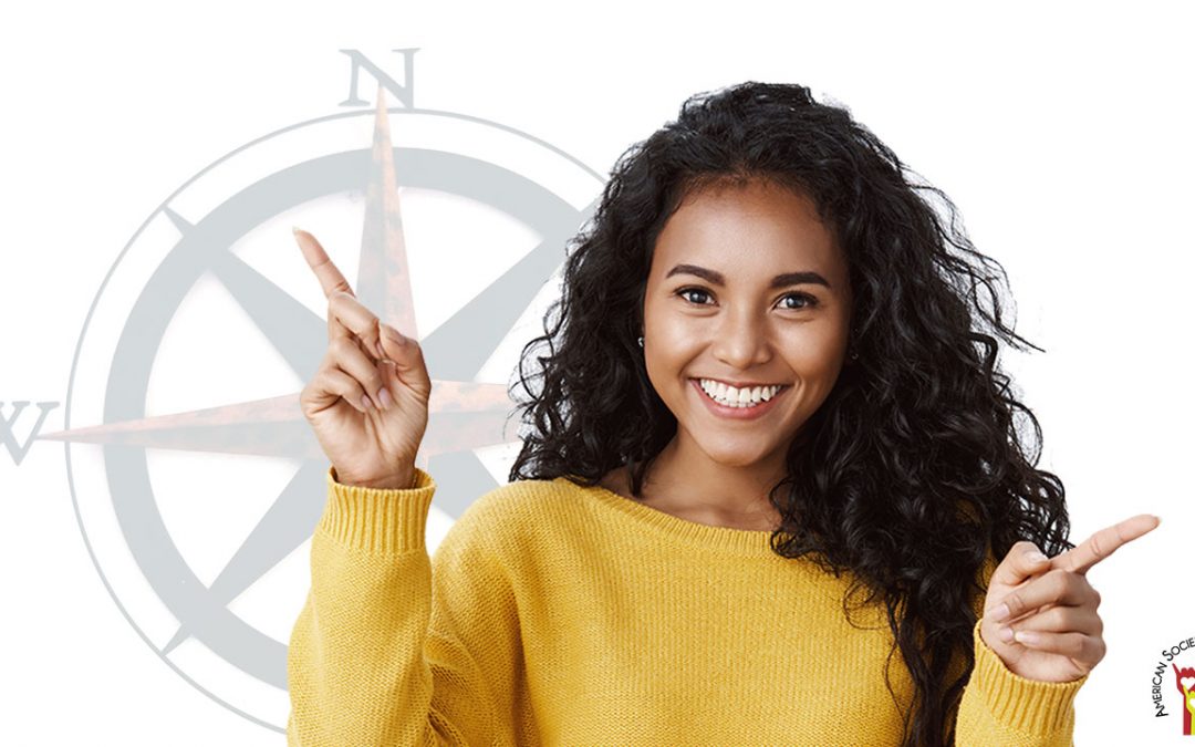 smiling woman pointing in two directions with a compass in the background