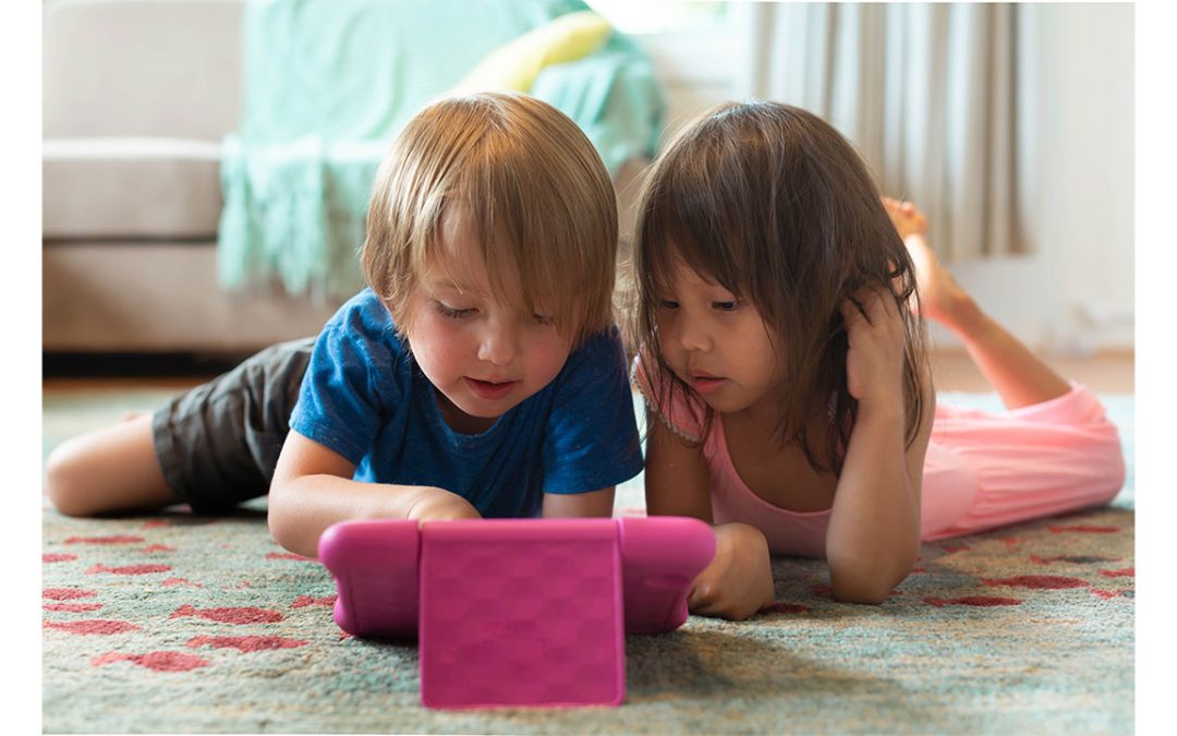 two children are looking at a tablet